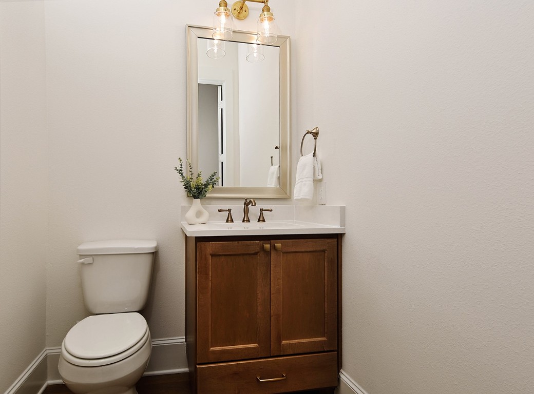 11709 Grand N Road Willis, TX 77378 - Photo 18 of 37 Powder room is upscale with rich wood stained vanity, quartz top and cabinet/drawer storage. Elegant fixtures and mirror.