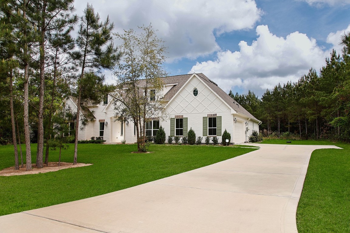 11709 Grand N Road Willis, TX 77378 - Photo 2 of 37 One-acre lot allows space for elongated driveway leads to side-entry 2-car garage, the most pleasing aesthetics on front elevation of home.
