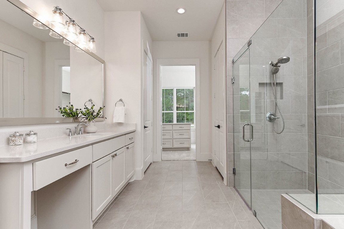 11709 Grand N Road Willis, TX 77378 - Photo 22 of 37 Sophisticated colors and finishes, two spacious vanities in quartz with elegant silver fixtures and custom walk-in closet.