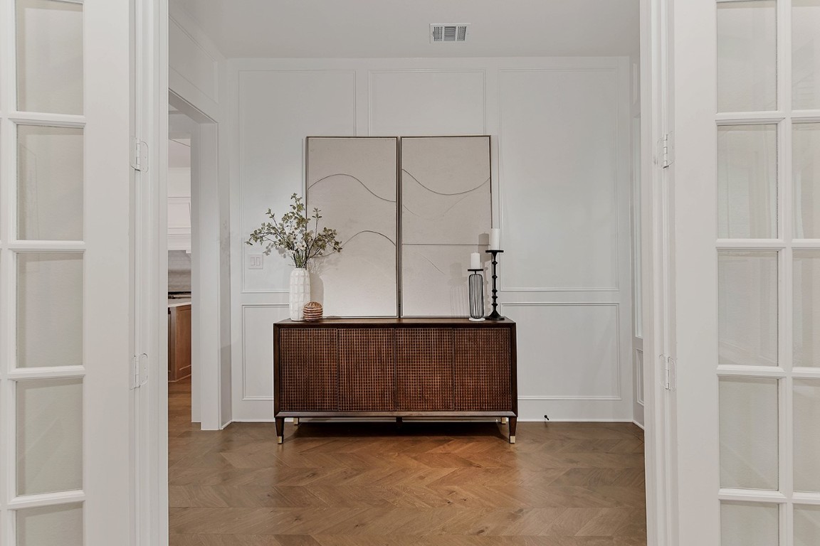11709 Grand N Road Willis, TX 77378 - Photo 5 of 37 This entryway is sophisticated with high end french oak wood flooring in a herringbone pattern, complementing the crisp white paneled walls perfectly.