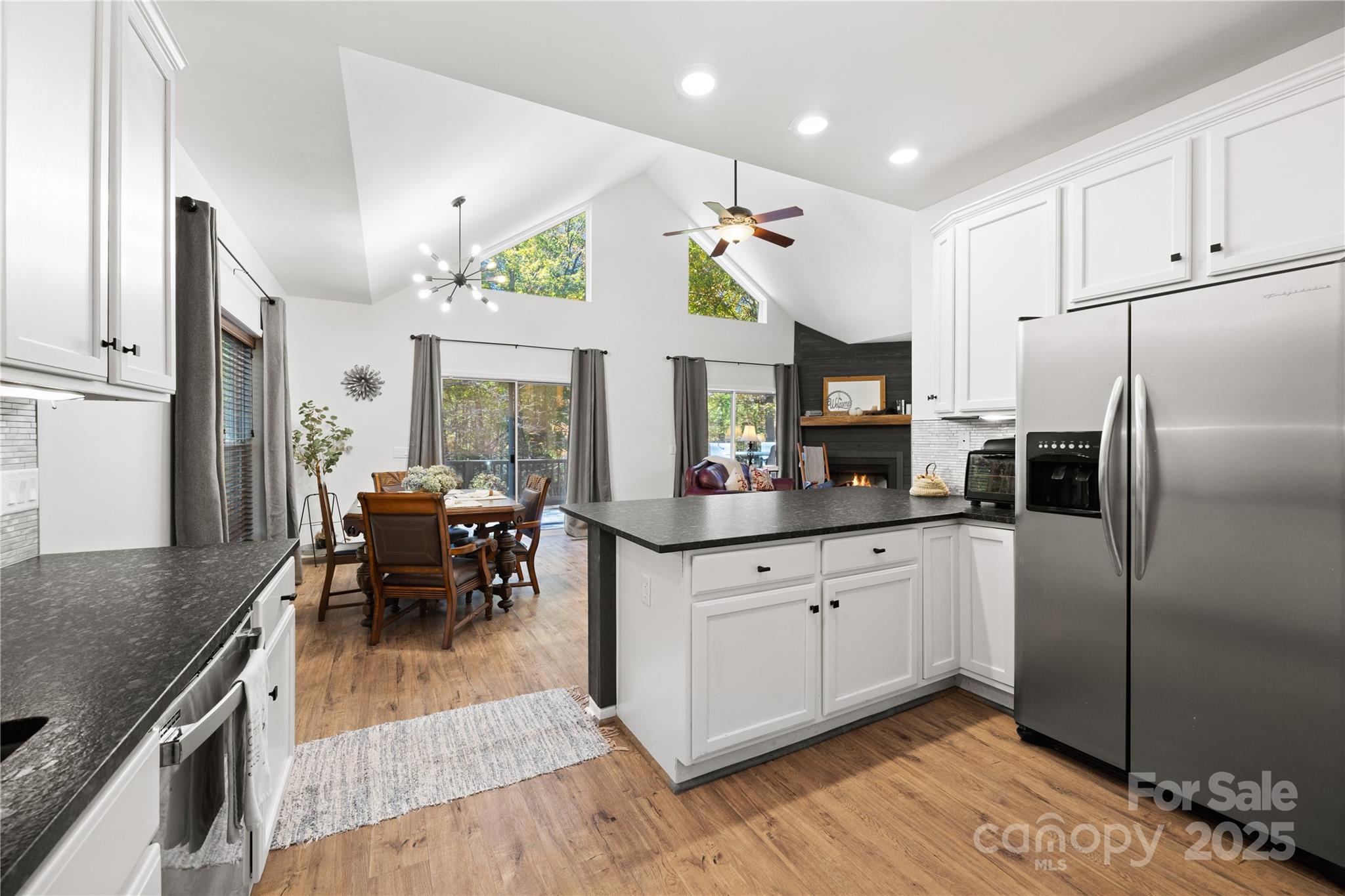 1308 Bell Mountain Road Zirconia, NC 28790 - Photo 11 of 42 a kitchen with granite countertop a refrigerator a stove a dining table and chairs with wooden floor