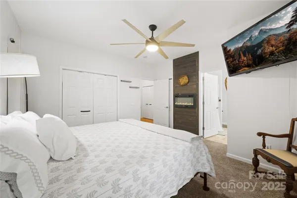 a bedroom with a bed and a flat tv screen on dresser