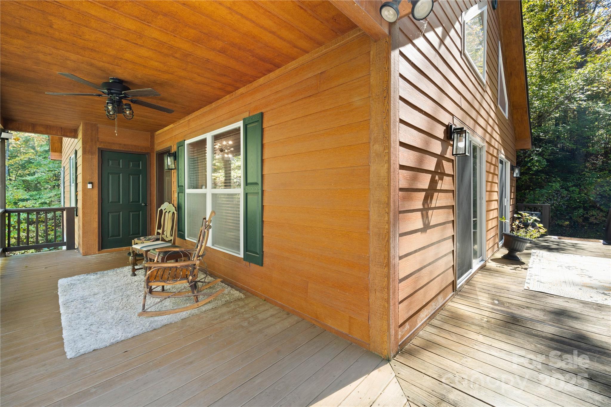 1308 Bell Mountain Road Zirconia, NC 28790 - Photo 31 of 42 a view of a patio with a table and chairs and floor to ceiling window with wooden fence