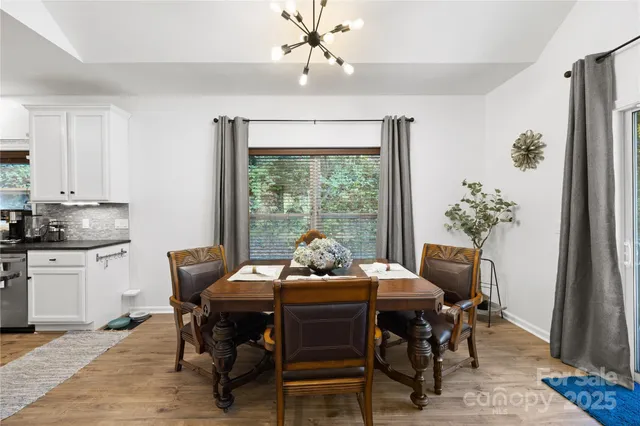 a dining room with furniture a chandelier and wooden floor
