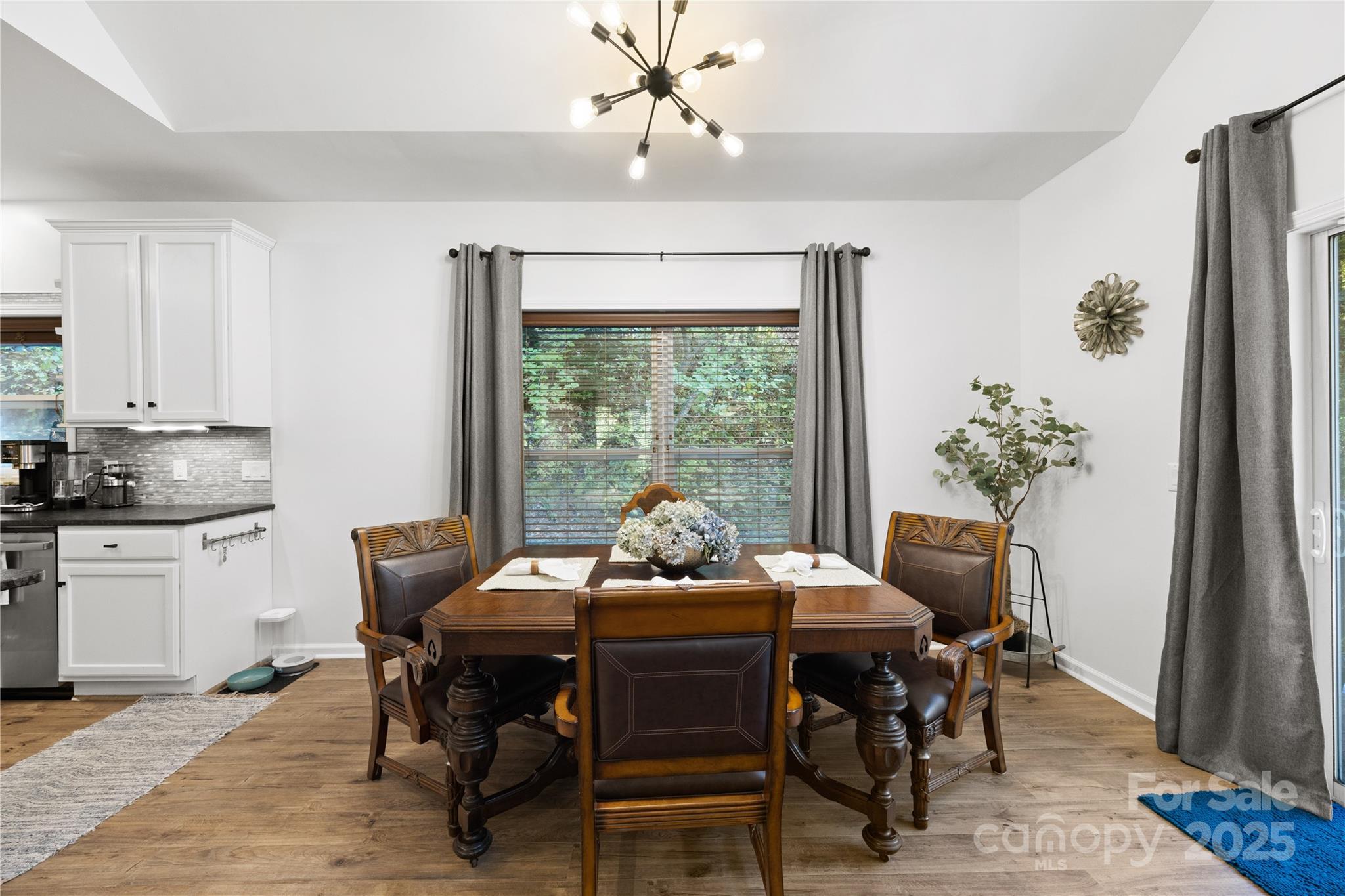 1308 Bell Mountain Road Zirconia, NC 28790 - Photo 7 of 42 a dining room with furniture a chandelier and wooden floor