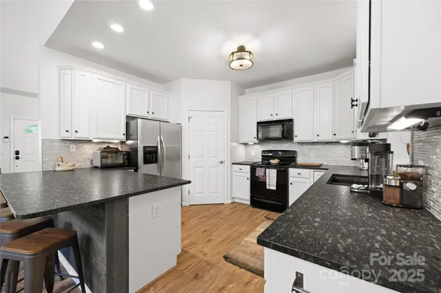 a kitchen with kitchen island a counter top space a sink stainless steel appliances and cabinets