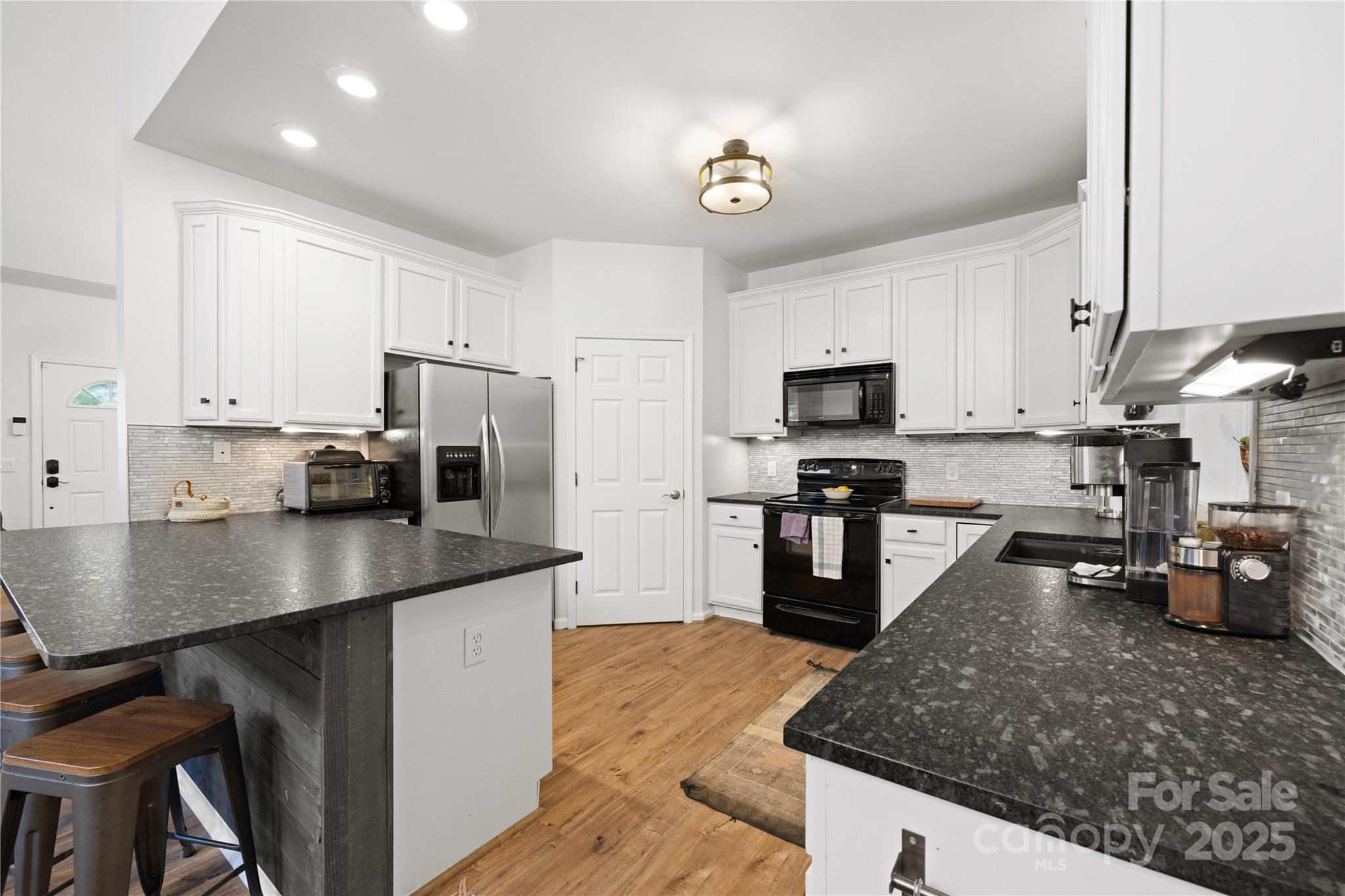1308 Bell Mountain Road Zirconia, NC 28790 - Photo 9 of 42 a kitchen with kitchen island a counter top space a sink stainless steel appliances and cabinets