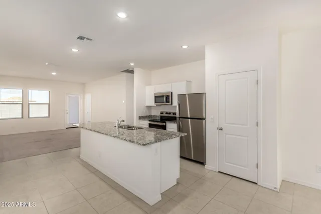 a large kitchen with a large counter top stainless steel appliances and cabinets