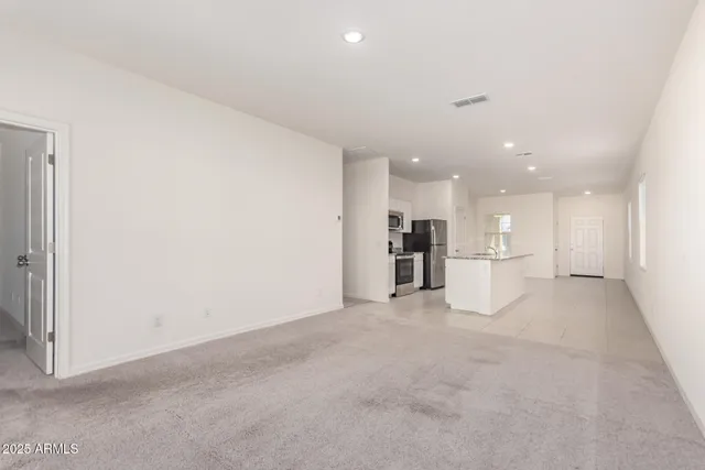 a view of kitchen with refrigerator and white cabinets