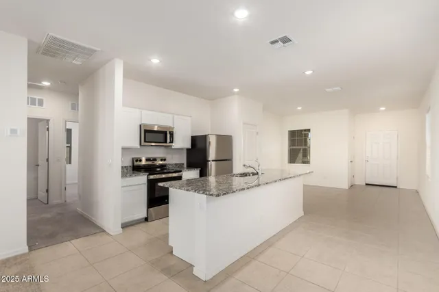 a large kitchen with stainless steel appliances lots of counter top space cabinets and a refrigerator