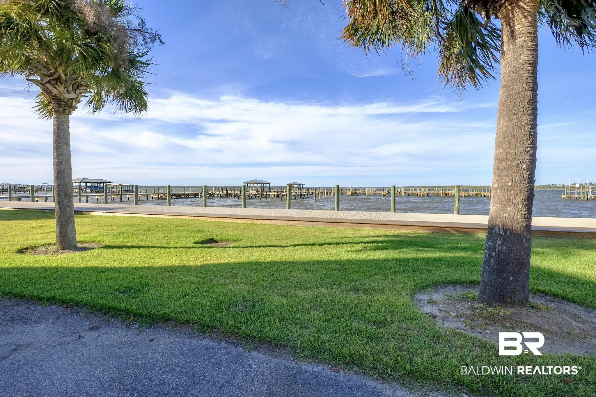 25861 Canal Road, Unit 1 Orange Beach, AL 36561 - Photo 22 of 53 Surrounding community featuring a lawn, a water view, and a dock