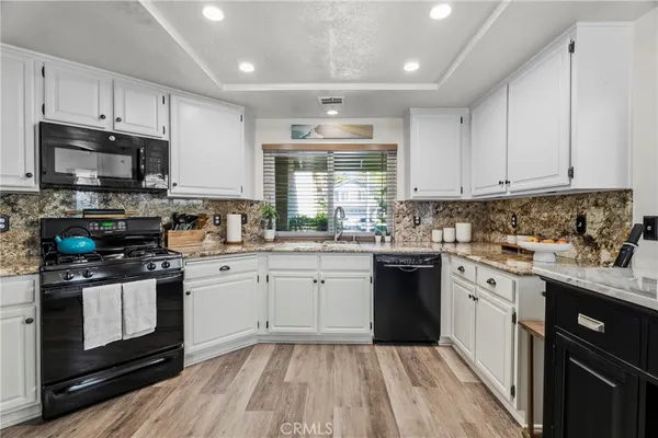 a kitchen with granite countertop cabinets stainless steel appliances a sink and window