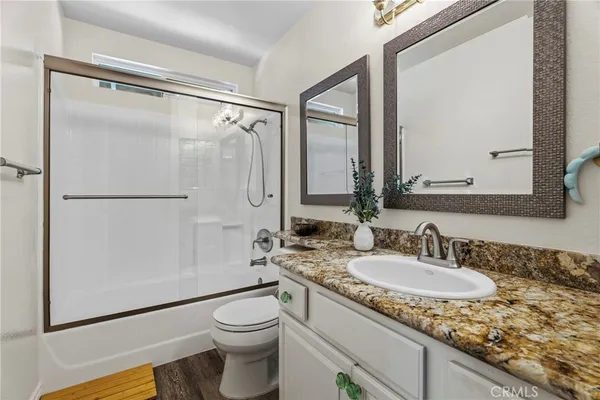 a bathroom with a granite countertop sink toilet and shower