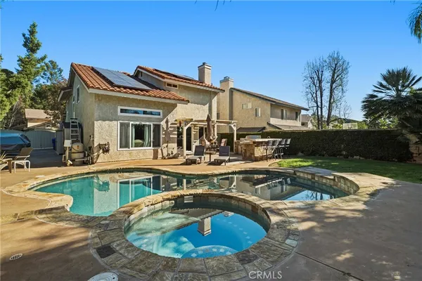 a view of a house with swimming pool and sitting area