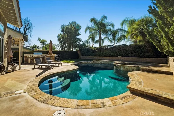 a view of a swimming pool with a yard and sitting area