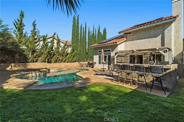 a view of a house with backyard and sitting area