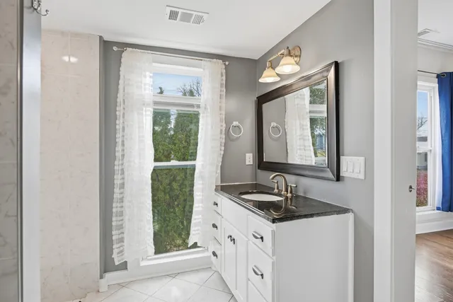 a bathroom with a granite countertop sink and a mirror