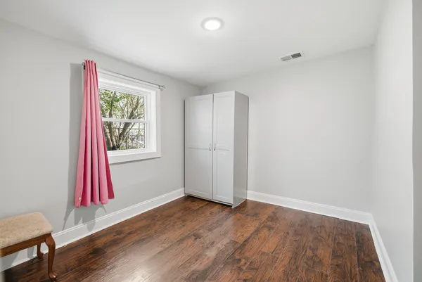 a view of hallway with wooden floor and door