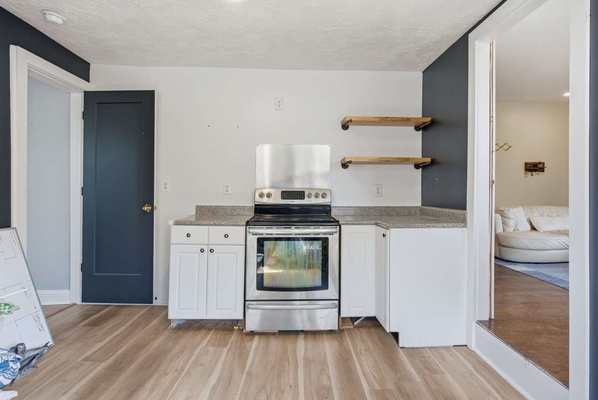 107 East Ward Street Centerville, TN 37033 - Photo 25 of 34 a kitchen with a stove and white cabinets
