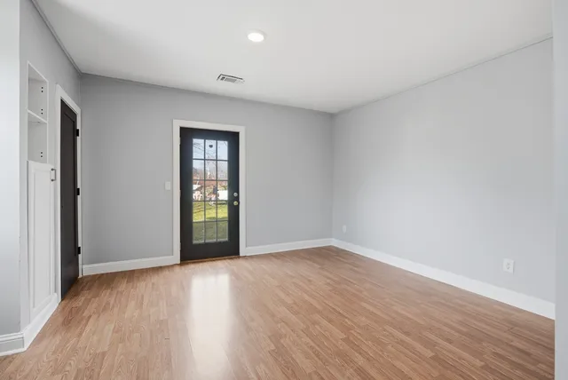 a view of an empty room with wooden floor