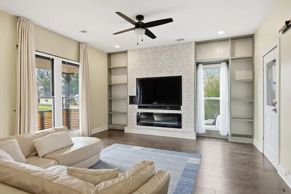 a living room with furniture ceiling fan and a flat screen tv