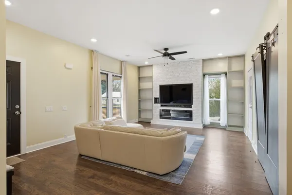 a living room with furniture wooden floor and a flat screen tv