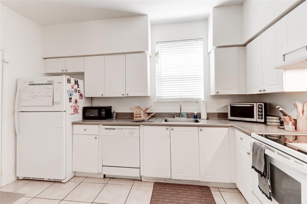 4004 Foxtail Palm Court, Unit 4004 Tampa, FL 33624 - Photo 12 of 49 a kitchen with cabinets appliances a sink and a window