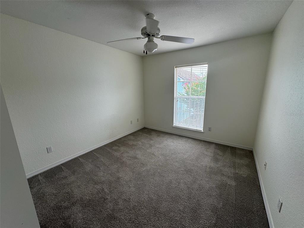 4004 Foxtail Palm Court, Unit 4004 Tampa, FL 33624 - Photo 34 of 49 an empty room with a ceiling fan and carpet