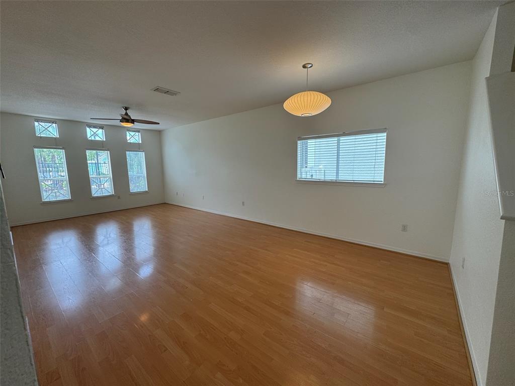 4004 Foxtail Palm Court, Unit 4004 Tampa, FL 33624 - Photo 6 of 49 an empty room with wooden floor and windows