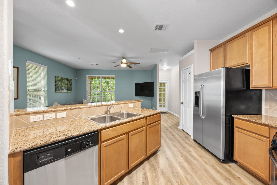 1310 West Parmer Lane, Unit 9B Austin, TX 78727 - Photo 10 of 38 a kitchen with granite countertop kitchen island stainless steel appliances a sink stove and refrigerator
