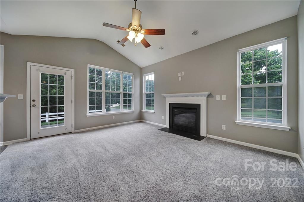 1704 Quartz Lane Fort Mill, SC 29708 - Photo 11 of 39 a view of an empty room with windows fireplace and chandelier