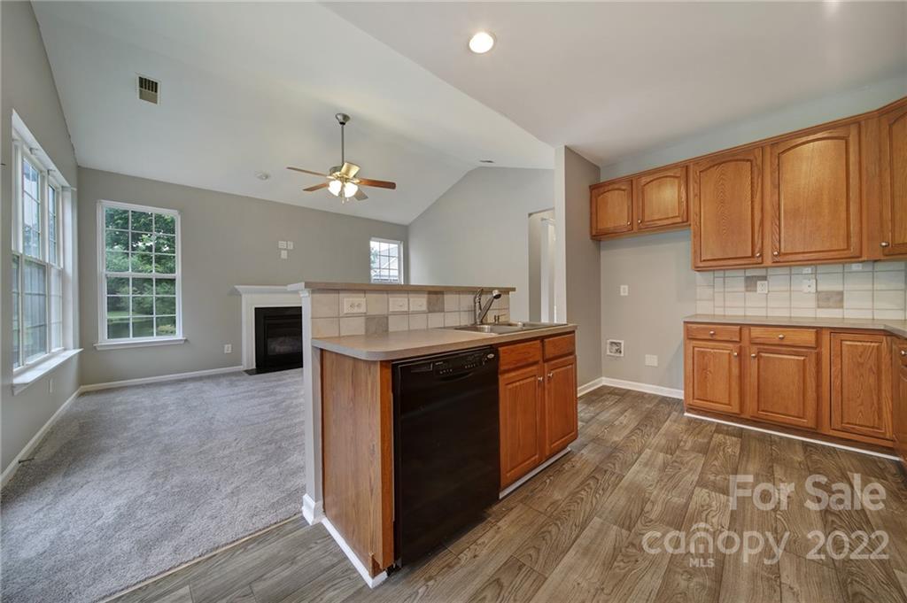 1704 Quartz Lane Fort Mill, SC 29708 - Photo 9 of 39 a kitchen with kitchen island granite countertop a stove a sink dishwasher and a fireplace with wooden floor