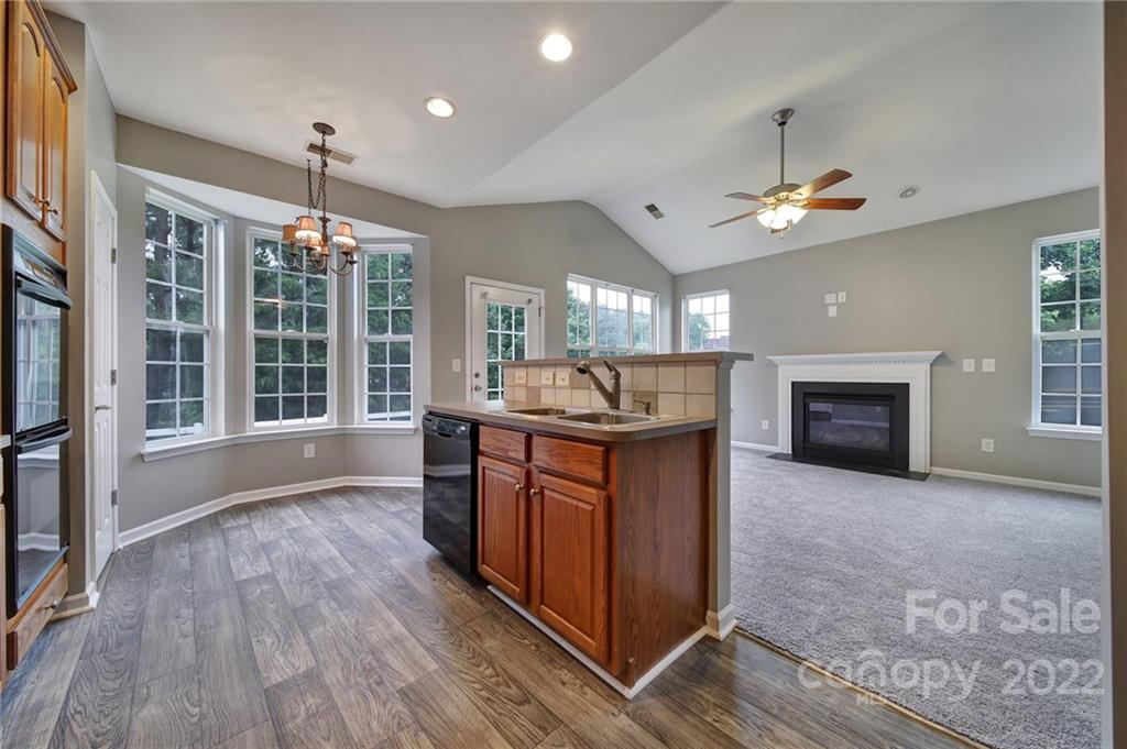 1704 Quartz Lane Fort Mill, SC 29708 - Photo 10 of 39 a kitchen with stainless steel appliances granite countertop a stove top oven a sink dishwasher a dining table and chairs with wooden floor