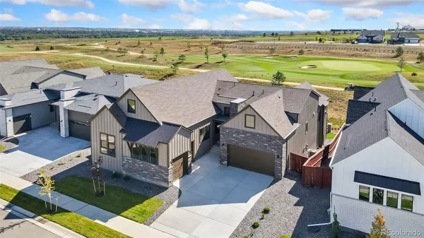 an aerial view of residential houses with outdoor space and ocean