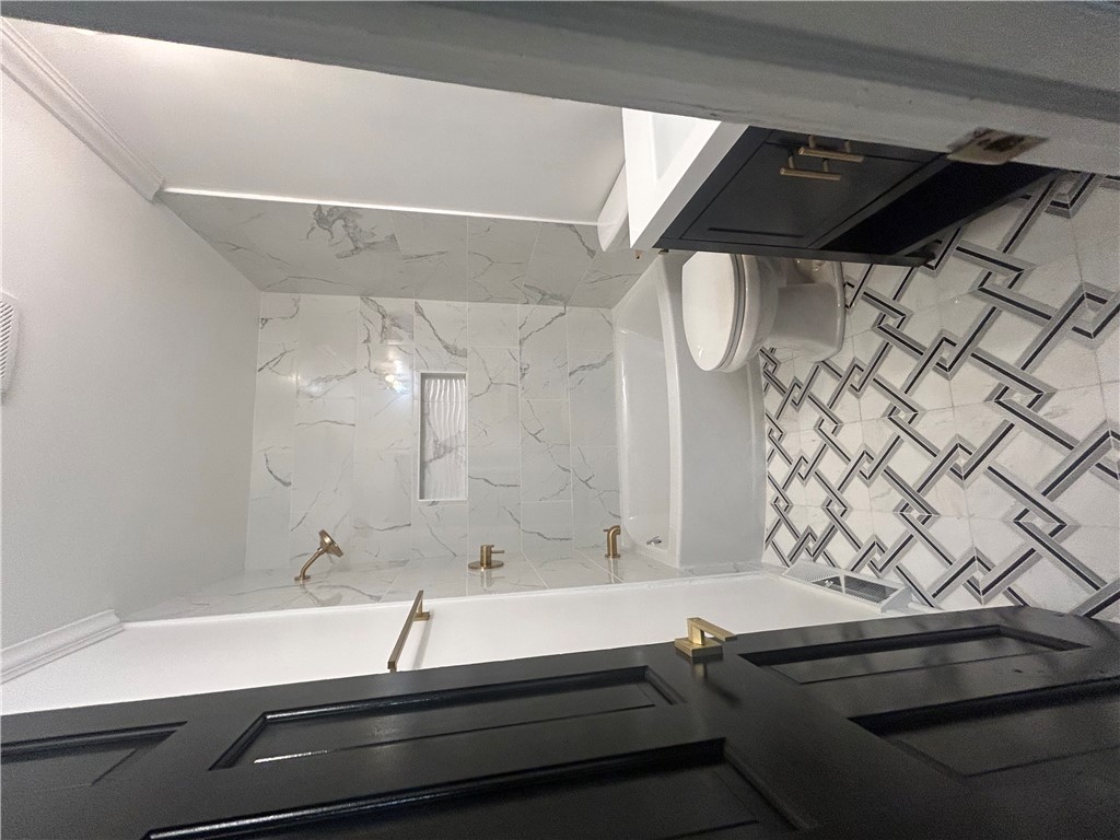 809 Paige Road Honea Path, SC 29654 - Photo 18 of 27 Elegant gold fixtures accent a pristine, tiled bathroom with sophisticated wall details.