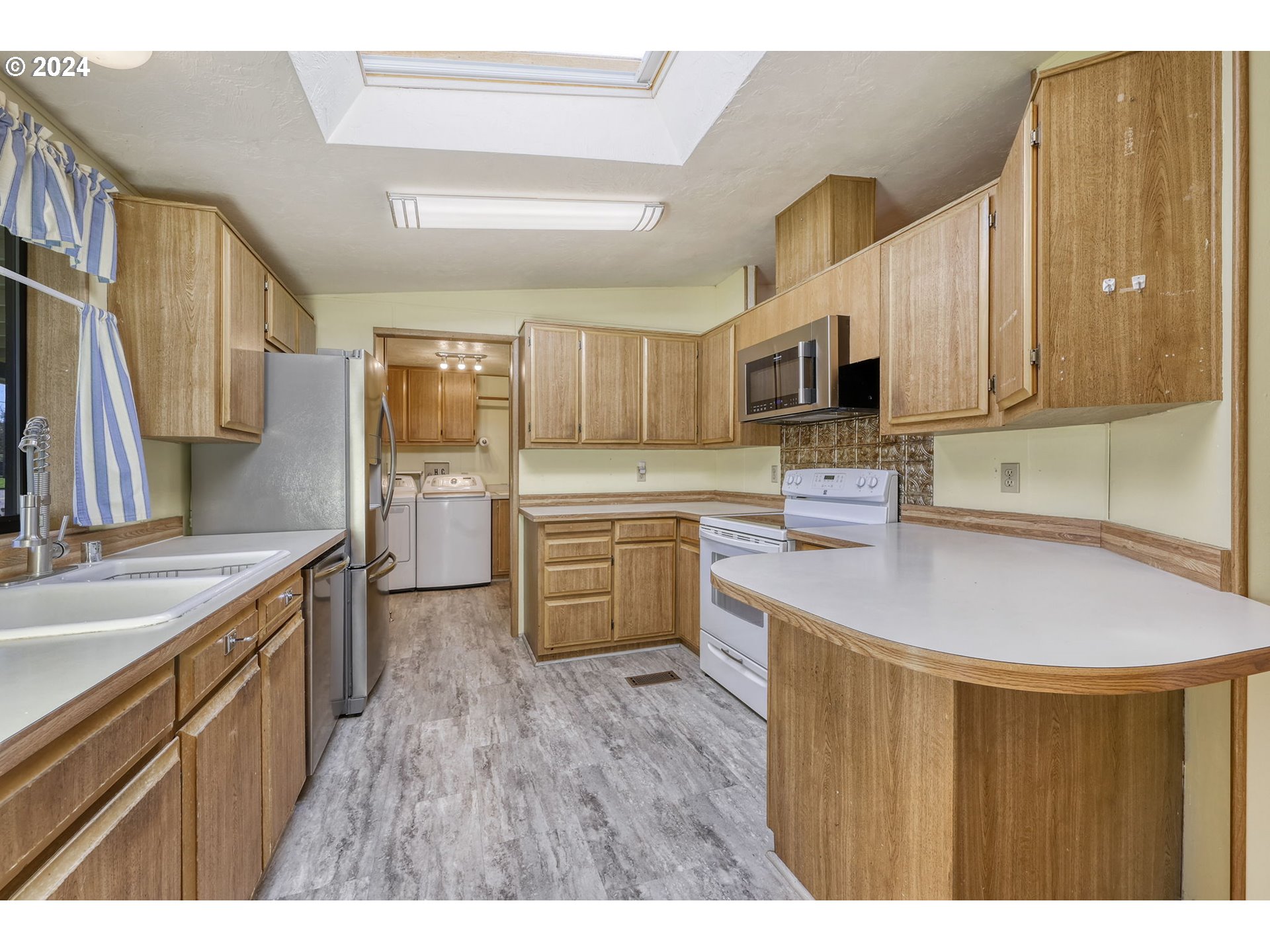 78414 Sears Road Cottage Grove, OR 97424 - Photo 14 of 44 a kitchen with stainless steel appliances a sink cabinets and a wooden floor