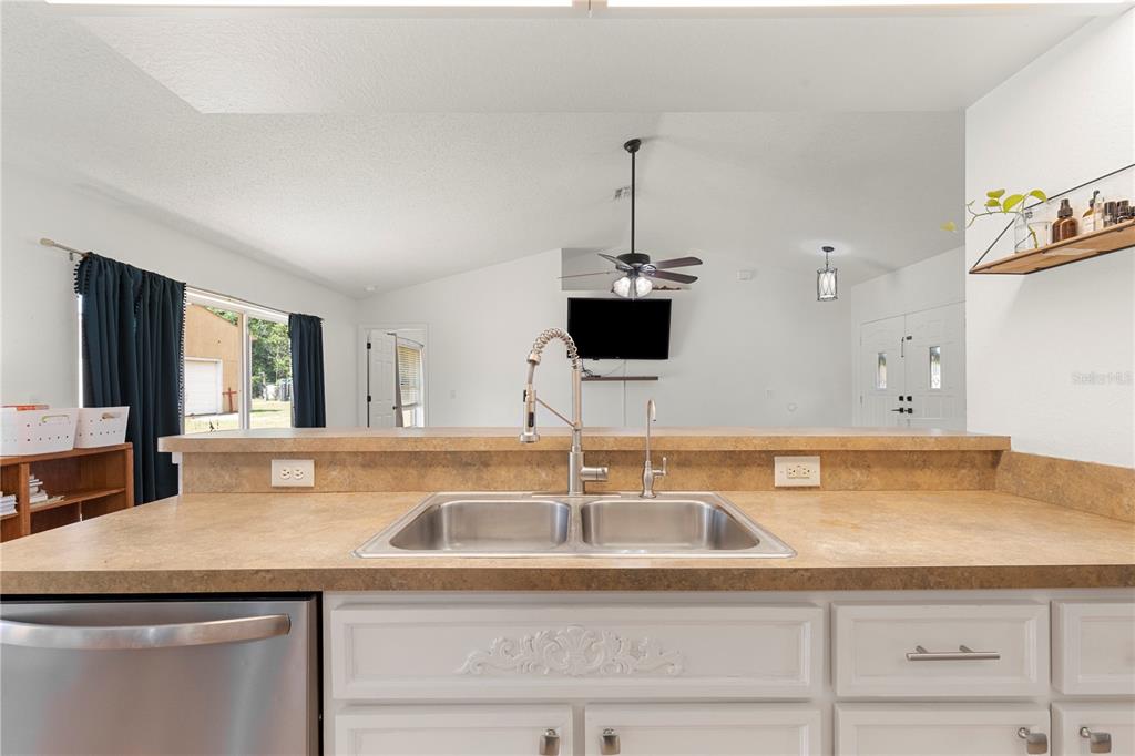 9917 Nelson Road Dade City, FL 33525 - Photo 15 of 40 a kitchen with stainless steel appliances granite countertop a sink and a wooden floor