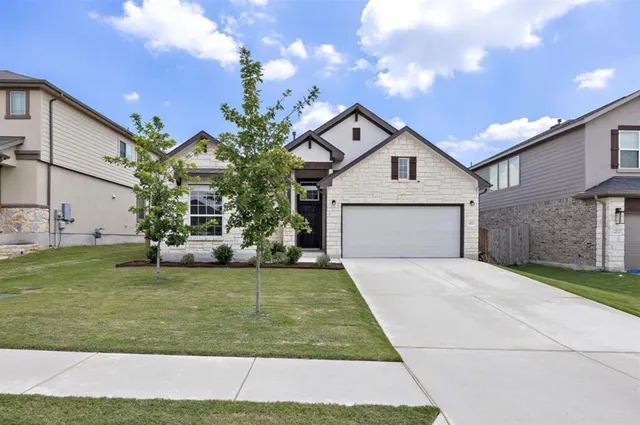 a front view of a house with a yard and garage