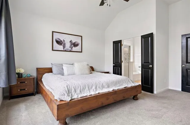 a spacious bedroom with a bed and painting on the wall