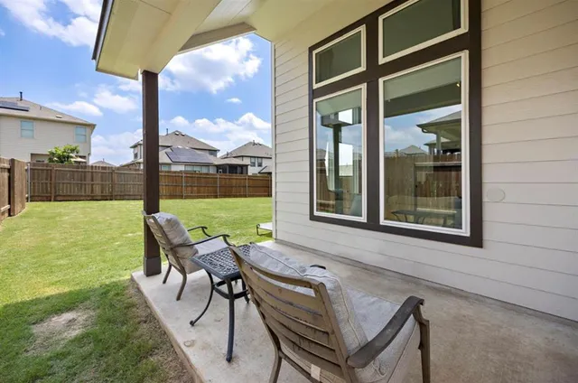 a view of a patio with a table chairs and a backyard