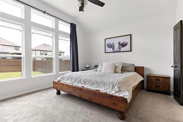 a spacious bedroom with a bed and a large window