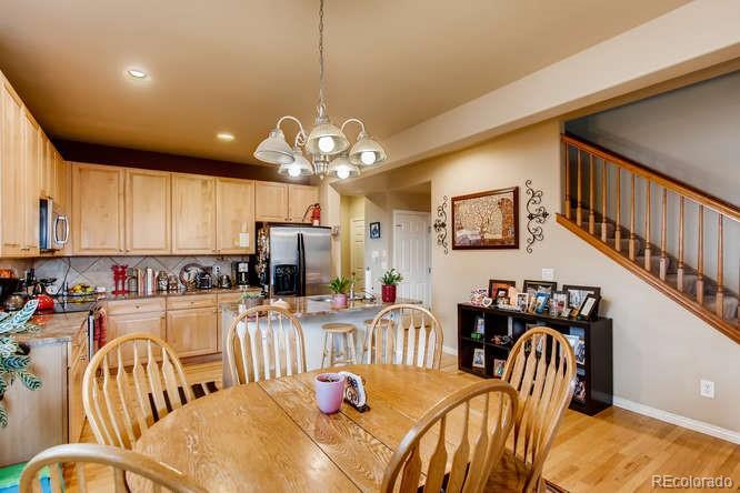 8068 Raspberry Drive Frederick, CO 80504 - Photo 11 of 26 a dining room with furniture a chandelier and wooden floor