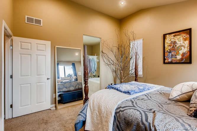8068 Raspberry Drive Frederick, CO 80504 - Photo 14 of 26 a bedroom with a bed and a mirror