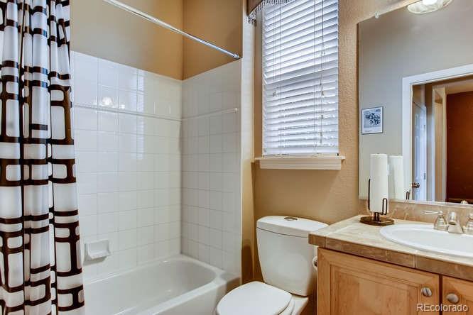8068 Raspberry Drive Frederick, CO 80504 - Photo 18 of 26 a bathroom with a granite countertop sink toilet a mirror and shower