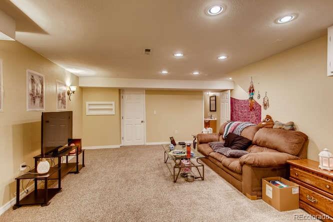 8068 Raspberry Drive Frederick, CO 80504 - Photo 23 of 26 a living room with furniture and a flat screen tv