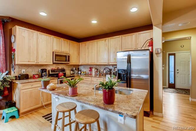 8068 Raspberry Drive Frederick, CO 80504 - Photo 8 of 26 a kitchen with sink refrigerator and microwave