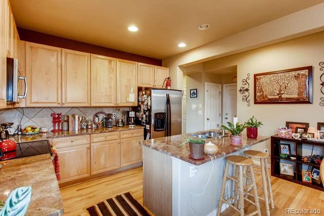 8068 Raspberry Drive Frederick, CO 80504 - Photo 9 of 26 a kitchen with stainless steel appliances granite countertop a sink and cabinets
