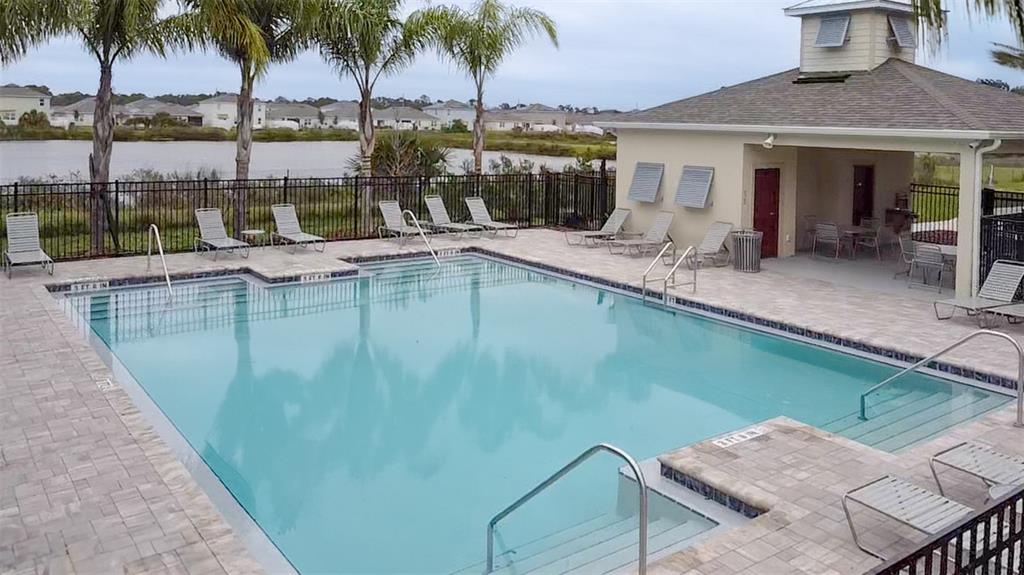 2802 Silver Canoe Drive Edgewater, FL 32141 - Photo 4 of 5 a view of a swimming pool with a lawn chairs under palm trees