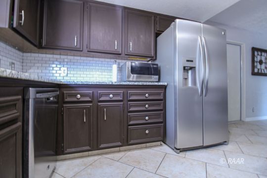 221 South Primrose Street Ridgecrest, CA 93555 - Photo 10 of 29 a kitchen with stainless steel appliances granite countertop a refrigerator and cabinets