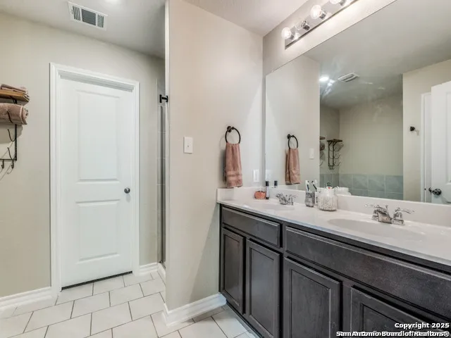 a bathroom with a double vanity sink and a mirror